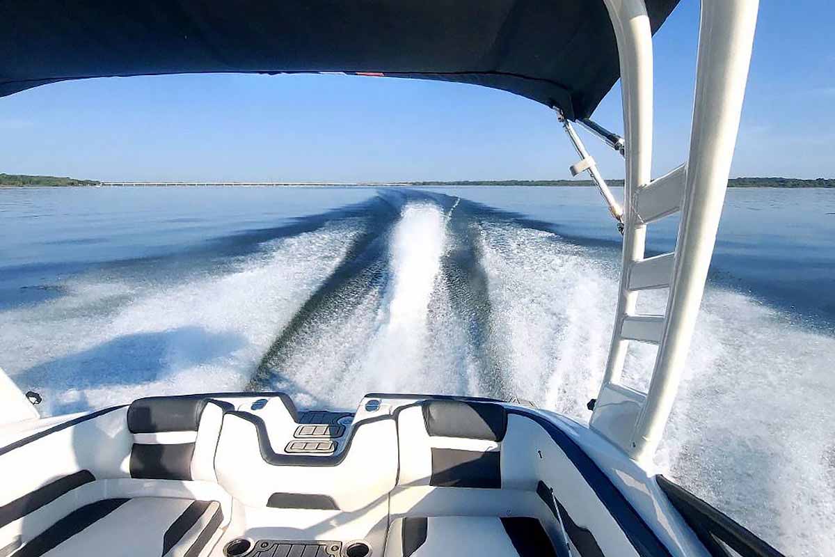 Motorboat leaving frothy wake.