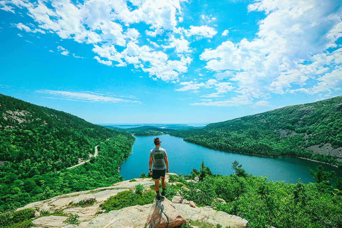 Man standing atop a mountain on the East Coast.