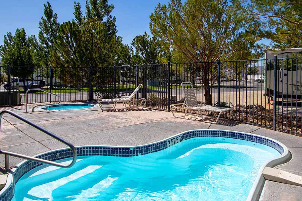 Pool and hot tub surrounded by RV park.