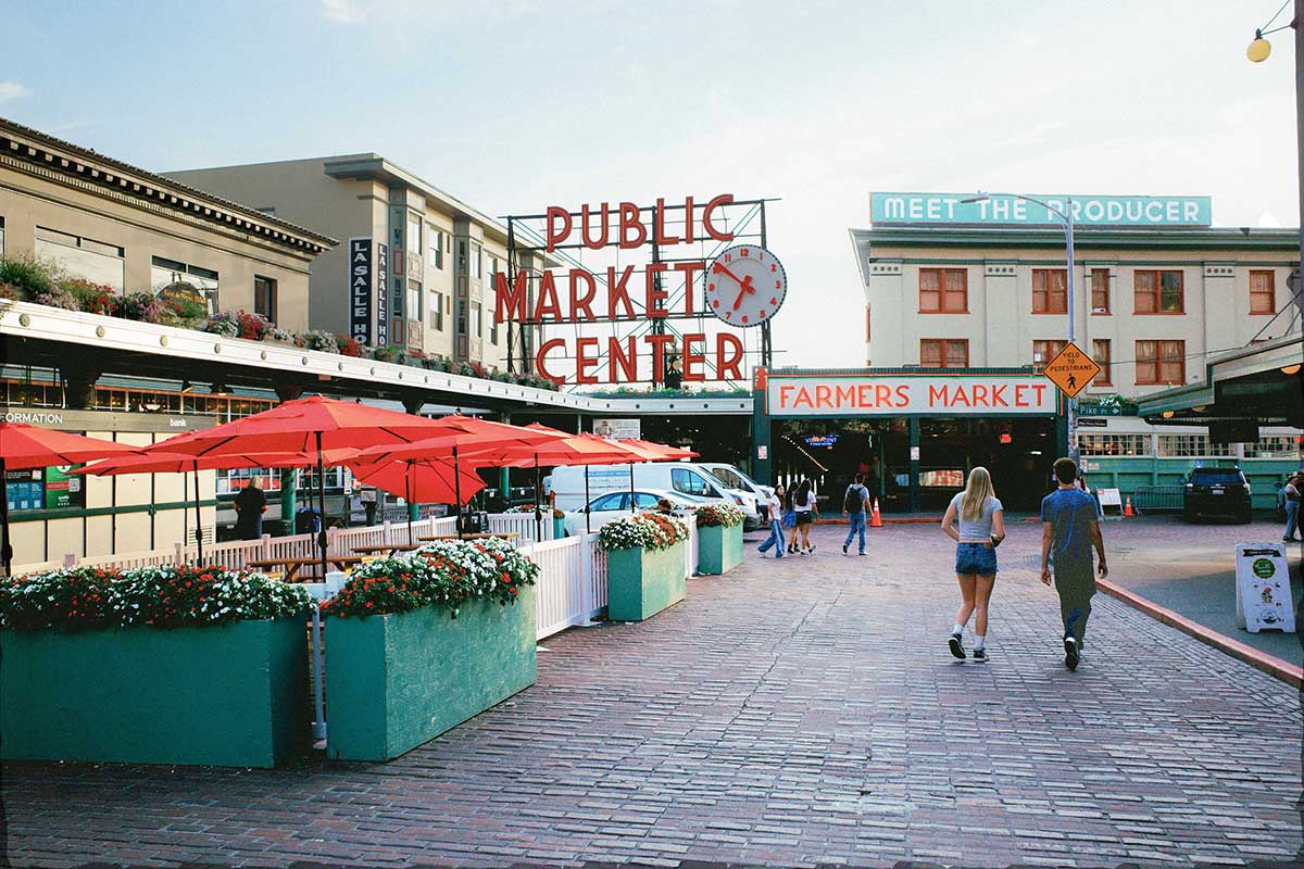 A couple walk toward a marketplace.