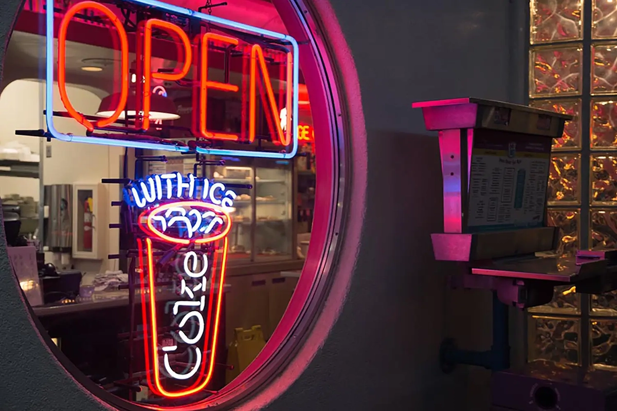 Neon light proclaiming coke and food.