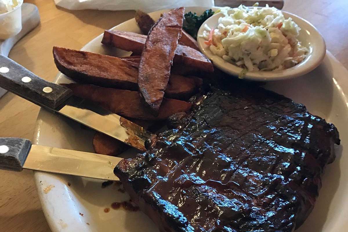 A plate with a big slab of barbecued ribs.
