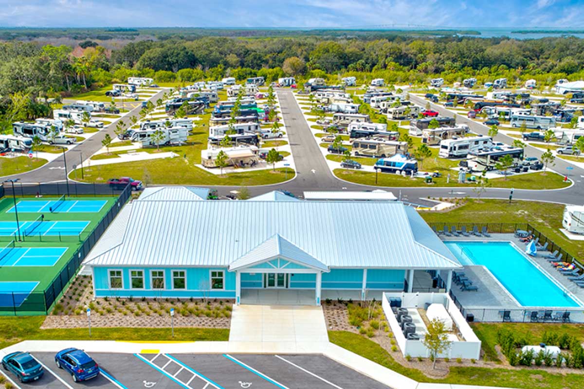 Aerial shot of clubhouse, pickleball courts and pool.