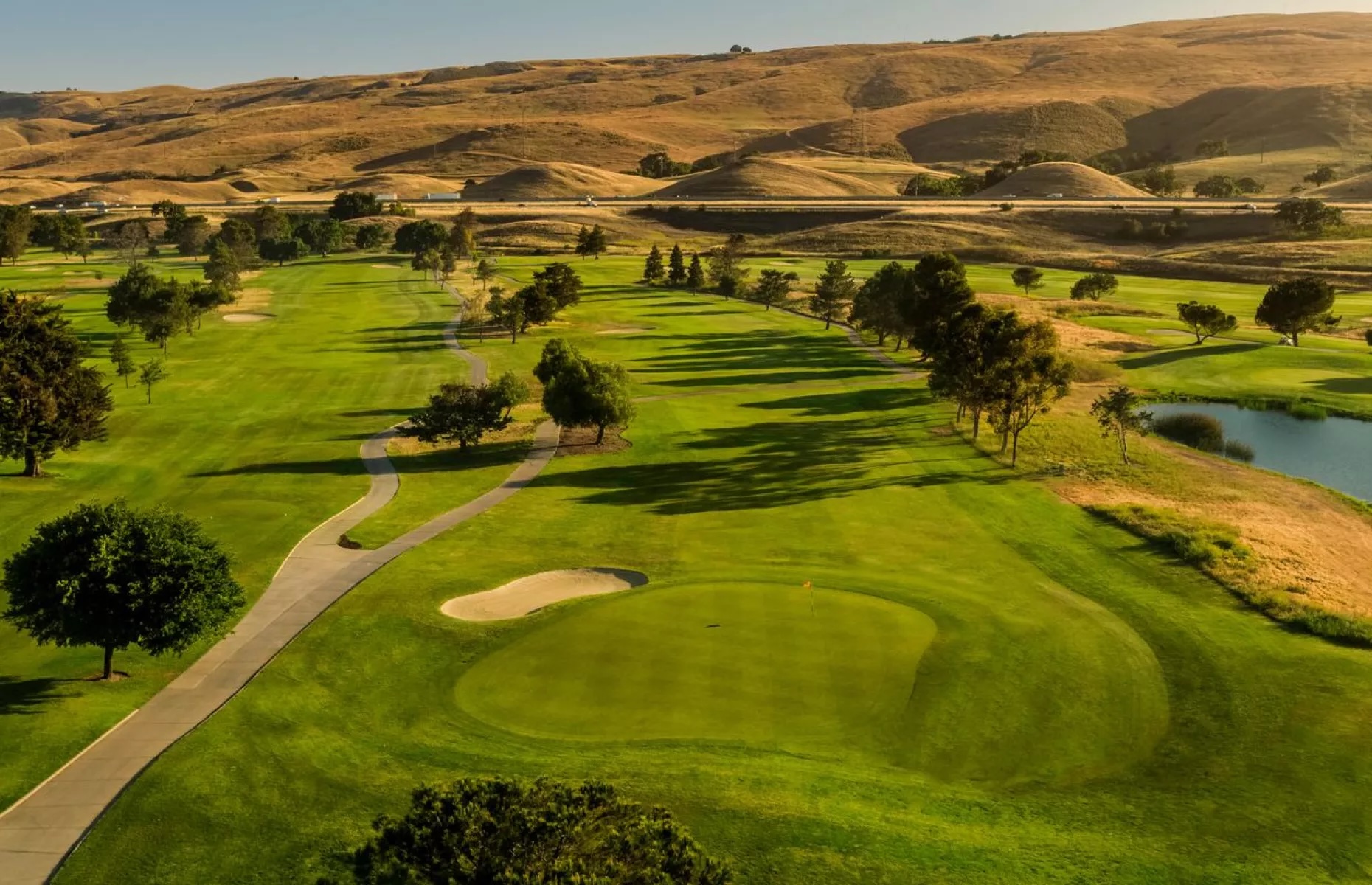 Golf course amid low-lying hills. 