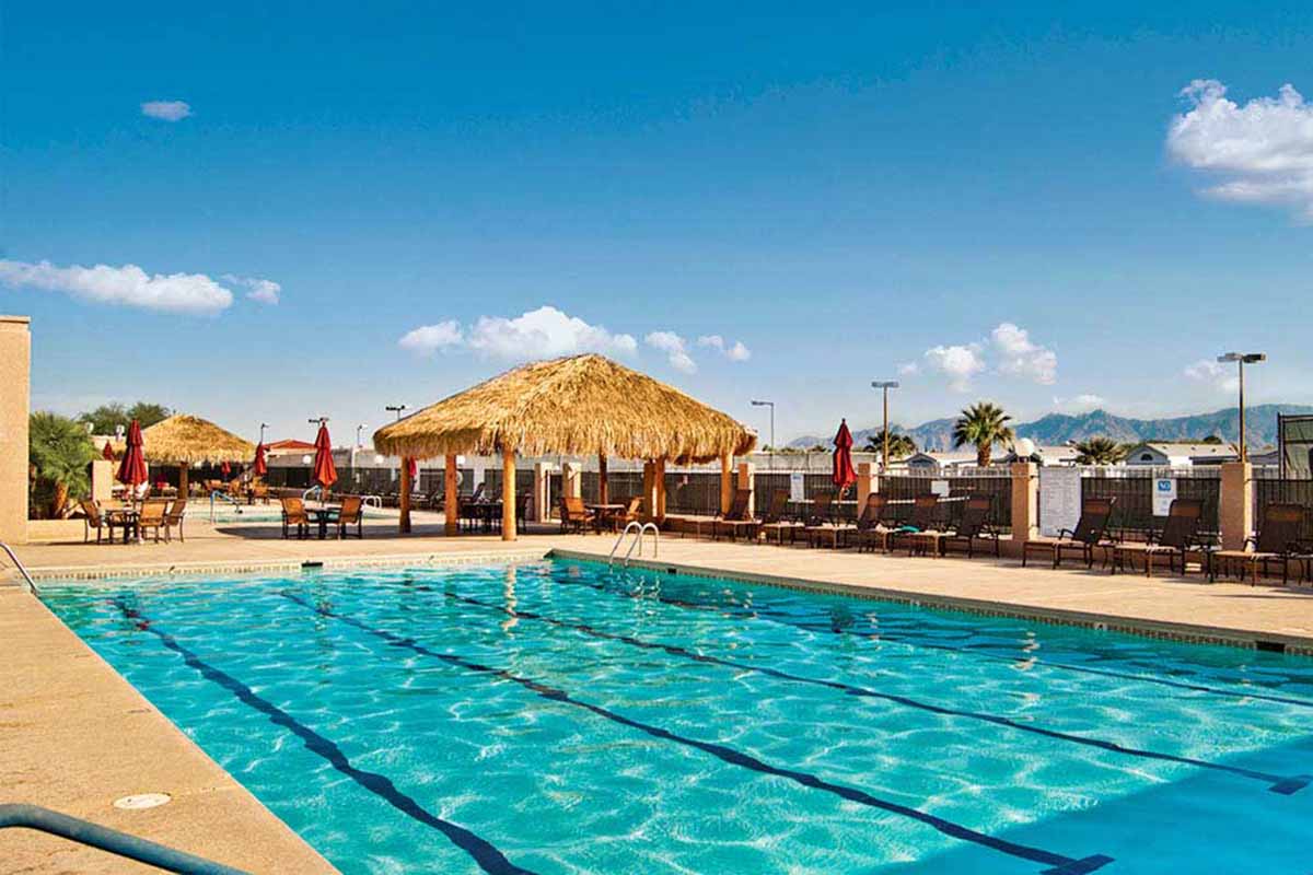 Pool near a grass-thatched pavilion.