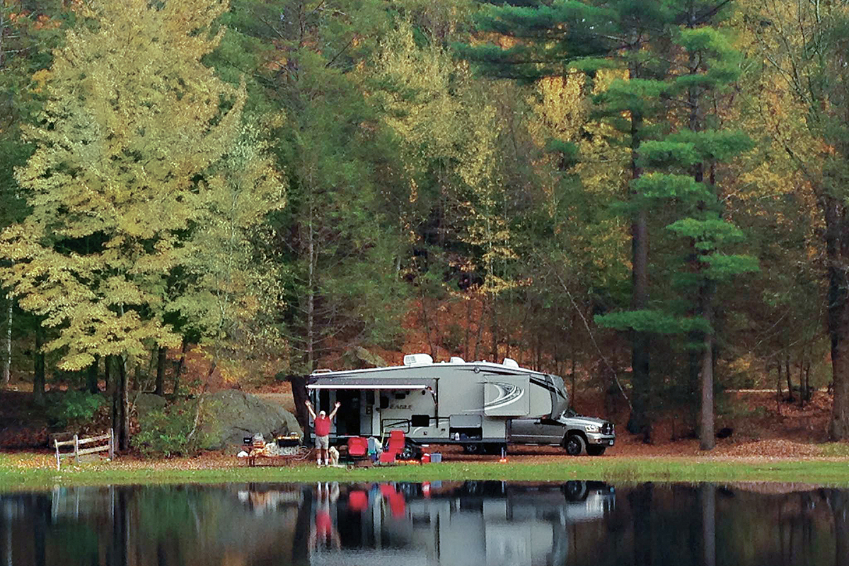 Fifth-wheel parked near lakeshore.