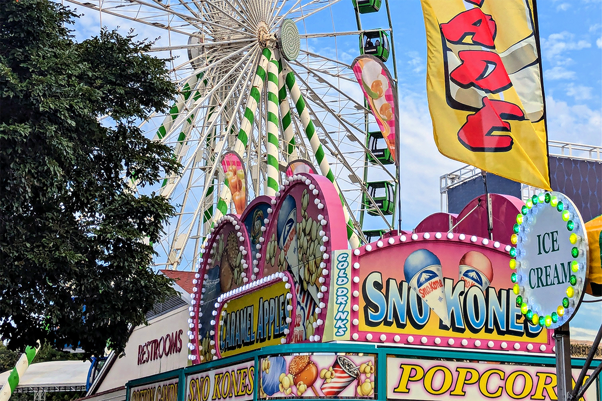 Popcorn stand and Ferris wheel on midway.