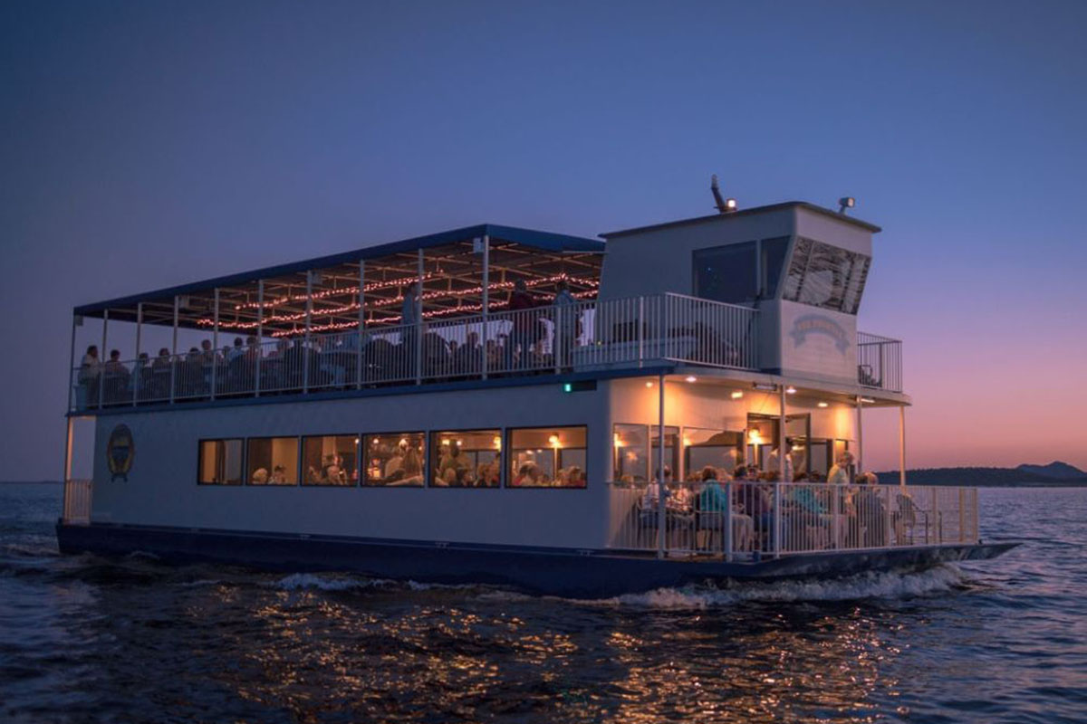 A two-decker cruise boat at sunset.