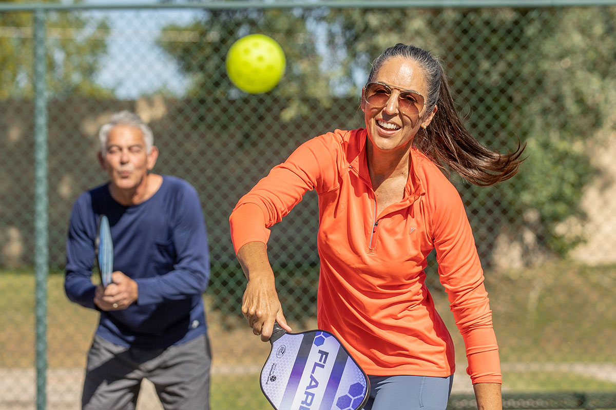 Man and woman play pickleball.