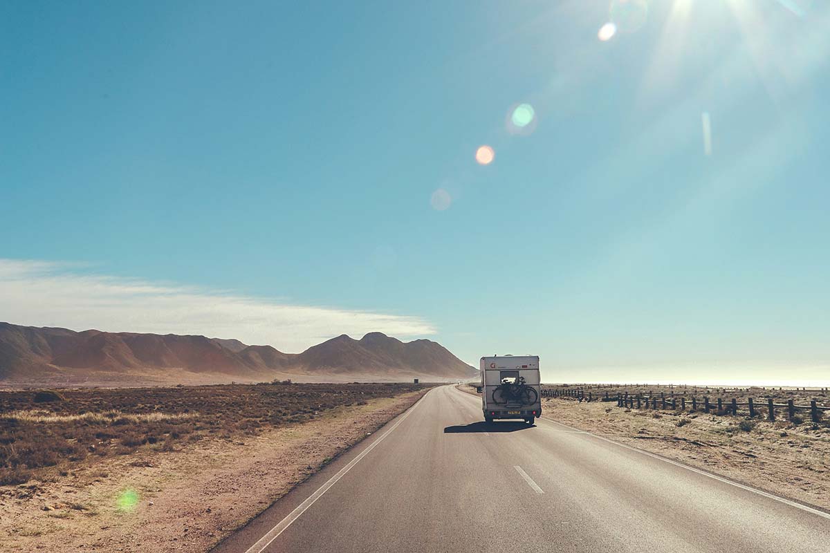 RV driving into a desert horizon.