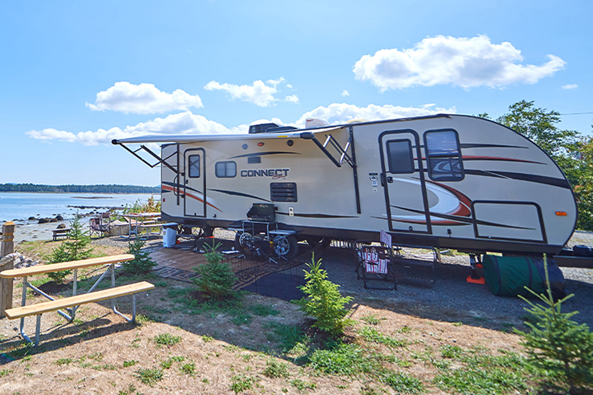 Travel trailer camping near lake.